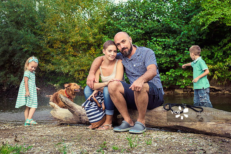 有两孩子的一家人坐在圆木上图片素材