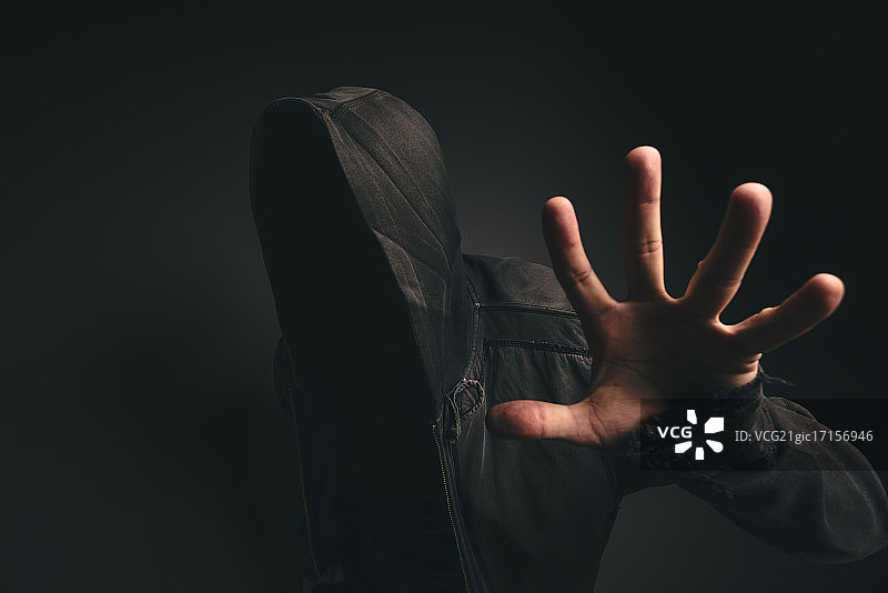黑暗房间里戴着兜帽的无脸人图片素材