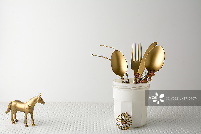 白色瓶子里的金色餐具刀叉图片素材