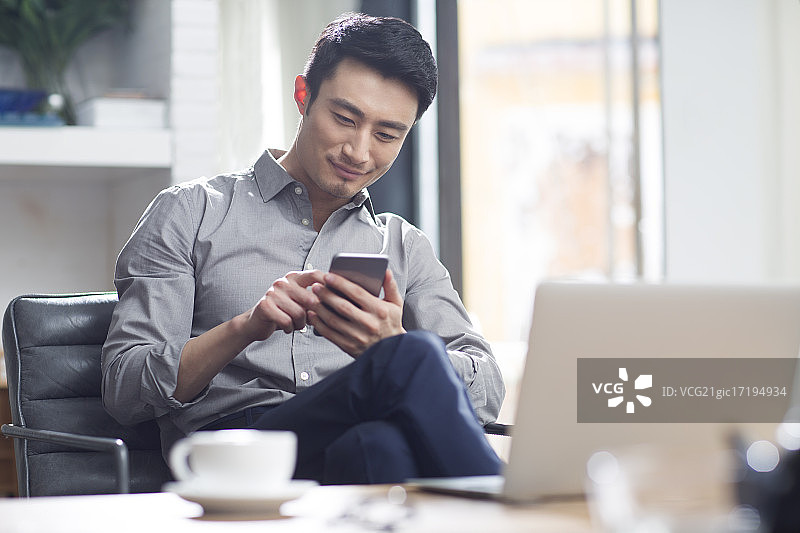 年轻商务男子在办公室使用手机图片素材
