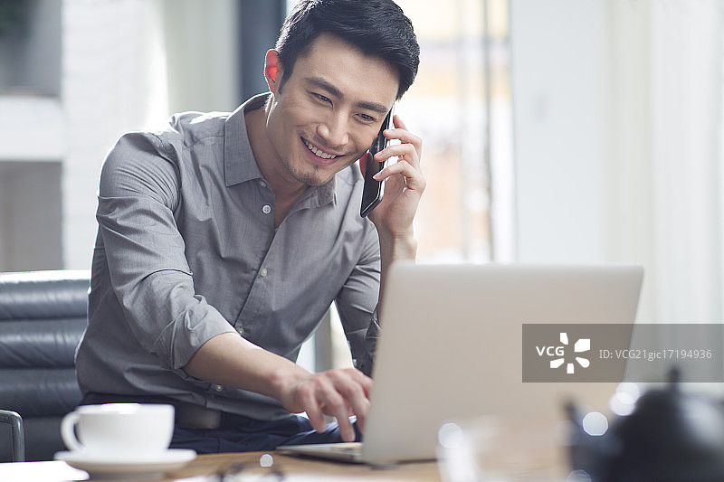 年轻商务男子在办公室打电话图片素材