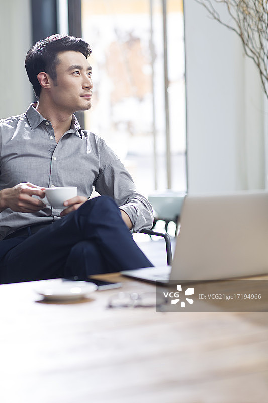 年轻商务男子在办公室喝咖啡图片素材