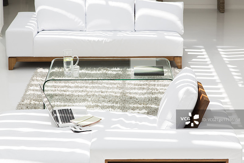 现代客厅中的笔记本电脑、沙发和咖啡桌图片素材