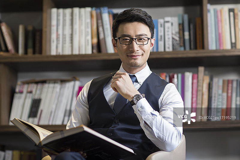 年轻商务男子在书房读书图片素材