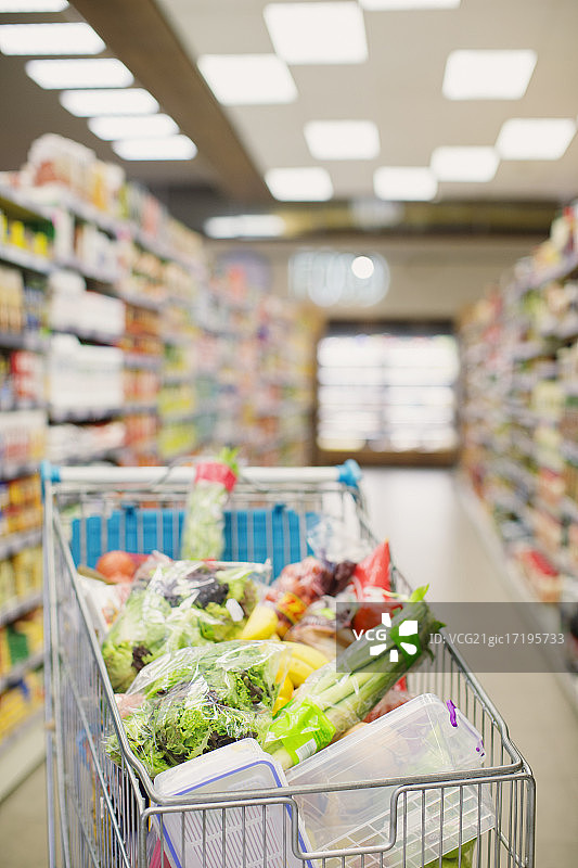 食品杂货店通道中的满载购物车图片素材
