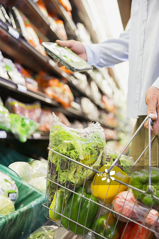男人在商店拿着装满购物篮的特写图片素材