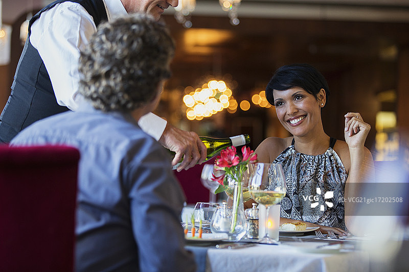 餐厅里倒白葡萄酒的中年夫妇图片素材