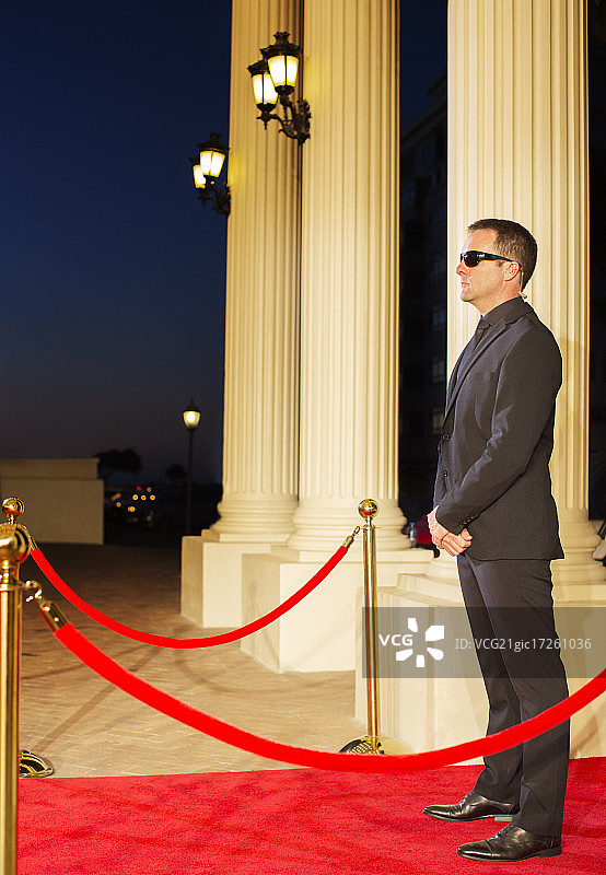 戴墨镜的严肃保镖在活动中保护红地毯图片素材