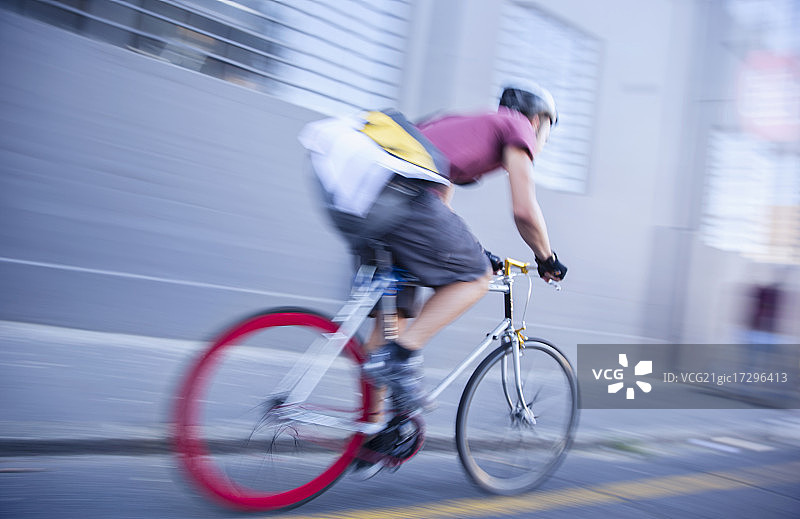 自行车信使在城市街道上飞驰图片素材