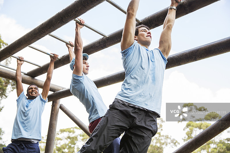 在训练营的单杠上训练的男人们图片素材