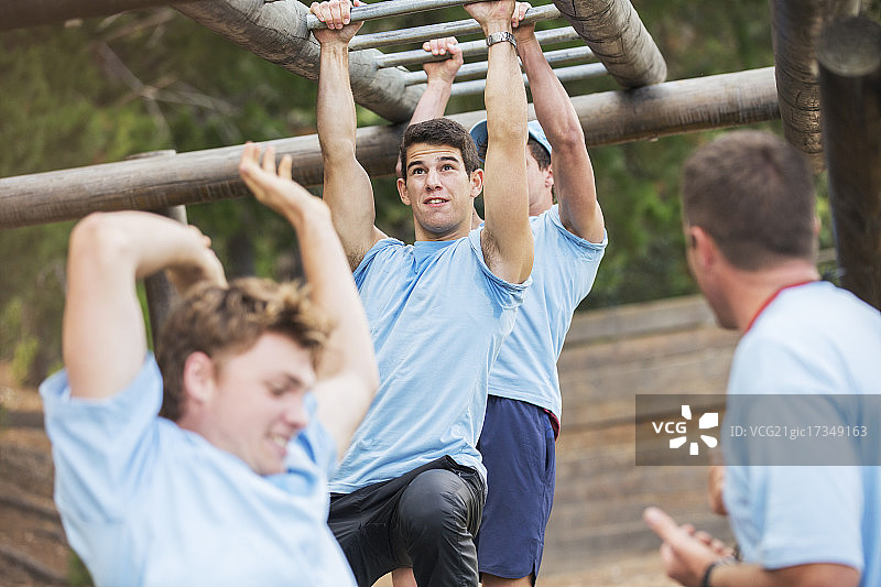 男子在障碍训练场上荡单杠图片素材