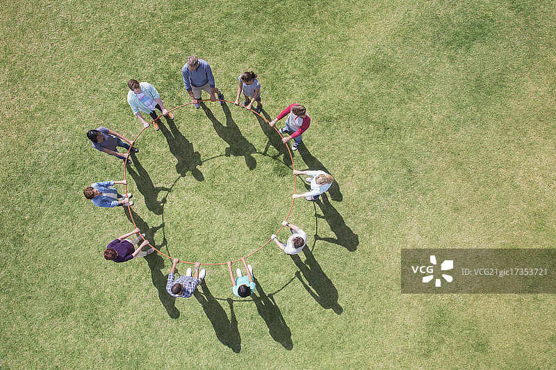团队围成一圈连接塑料圈的俯视图图片素材
