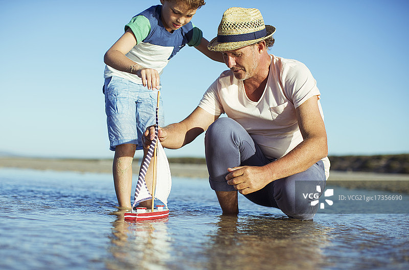 祖孙俩在水中玩玩具船图片素材