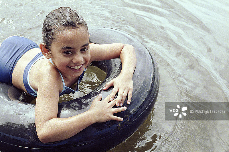 女孩在游泳圈上漂浮图片素材