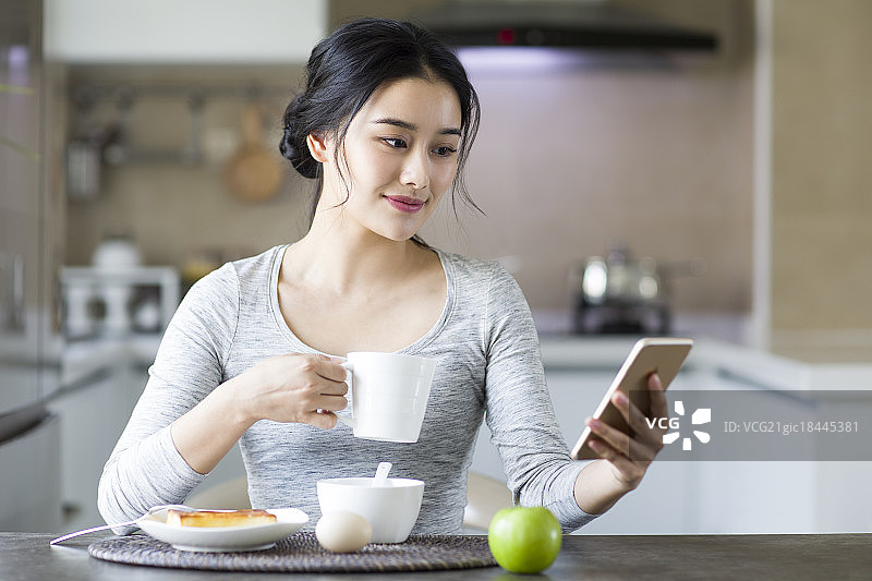 年轻女子在家吃早餐图片素材