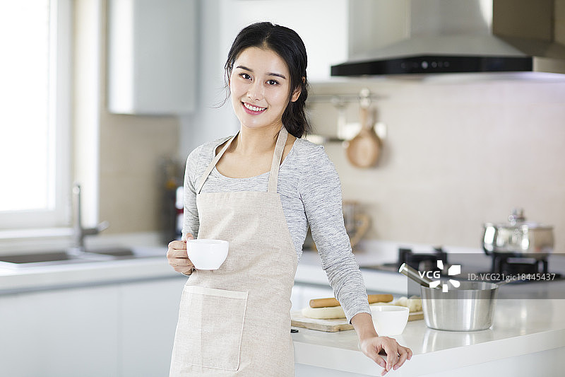 年轻女子在厨房喝咖啡图片素材