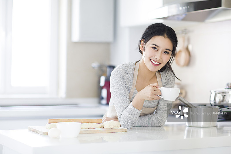 年轻女子在厨房喝咖啡图片素材