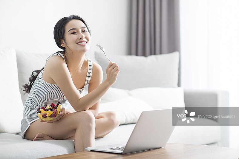 年轻女子在家使用笔记本电脑图片素材