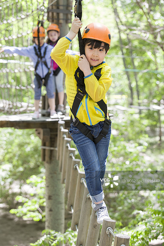 快乐的孩子们挑战树上穿越项目图片素材