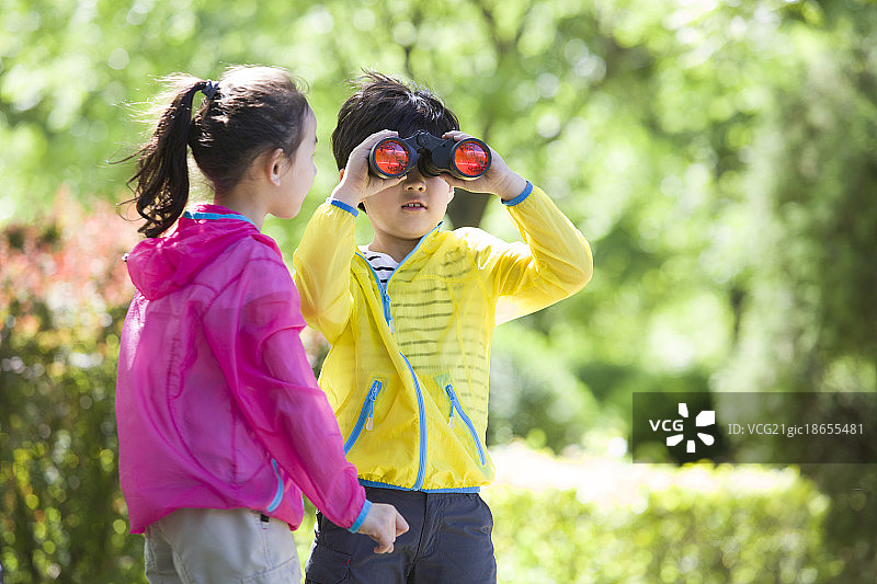 儿童在树林里使用望远镜图片素材