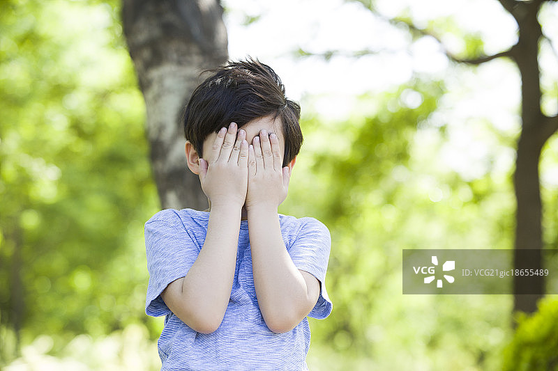 小男孩双手捂住眼睛图片素材