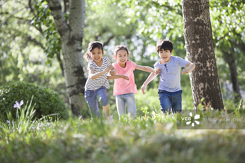 快乐的儿童在树林里赛跑图片素材