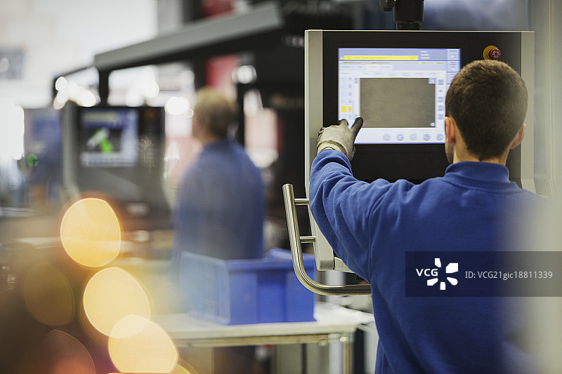 钢铁厂控制面板前的工人图片素材