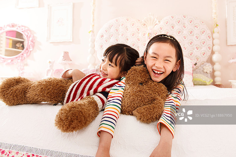 可爱的小女孩在床上玩耍图片素材