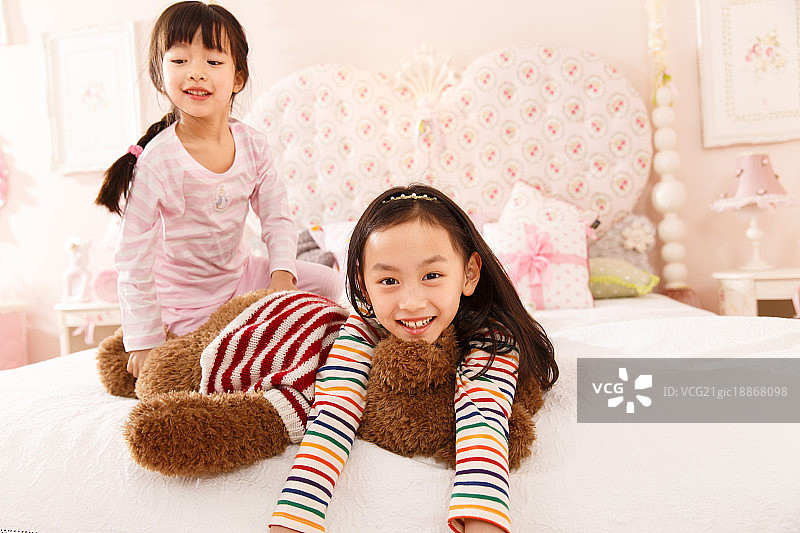 可爱的小女孩在床上玩耍图片素材