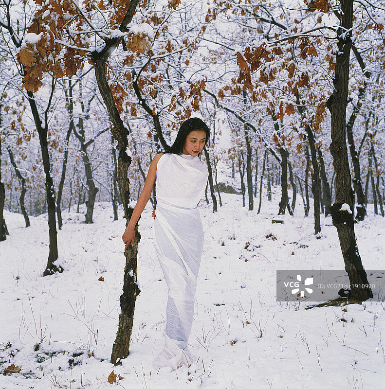 东方女人在雪地上散步图片素材