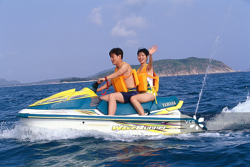 东方情侣在海上开汽艇图片素材