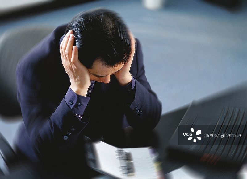 俯拍东方男人在室内痛苦的沉思图片素材