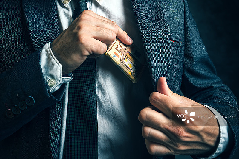 口袋里的钱：商人将欧元纸币放入西装口袋图片素材