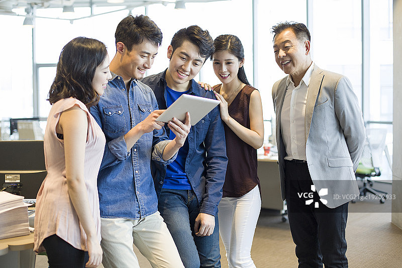 商务男士向同事展示平板电脑图片素材