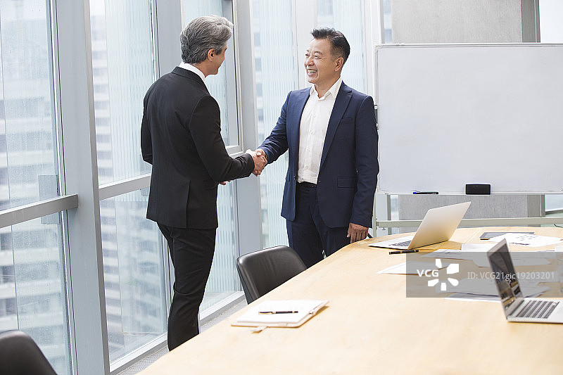 商务男士在会议室握手图片素材
