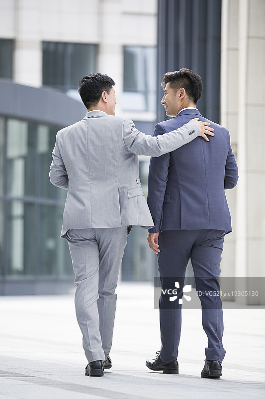 自信的商务男士边走边谈论图片素材