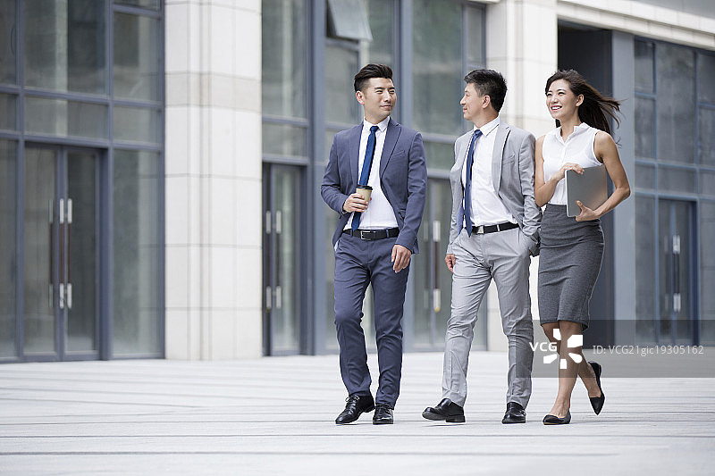 自信的商务人士边走边谈论图片素材
