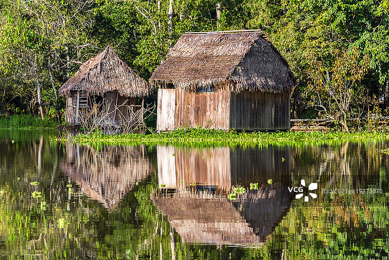 亚马逊河中倒映的棚屋图片素材
