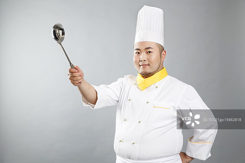 年轻的胖厨师拿着长柄勺图片素材