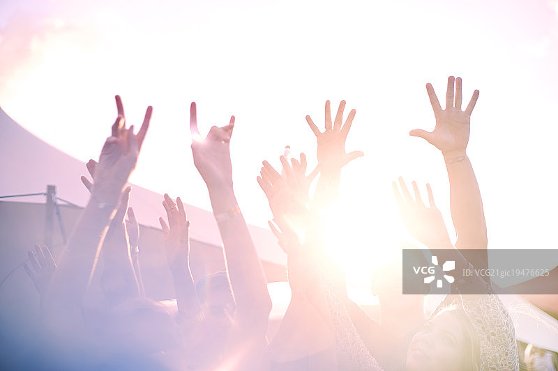 在阳光明媚的音乐节上手臂高举欢呼图片素材