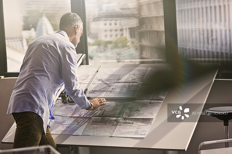 建筑师在办公室审查蓝图图片素材