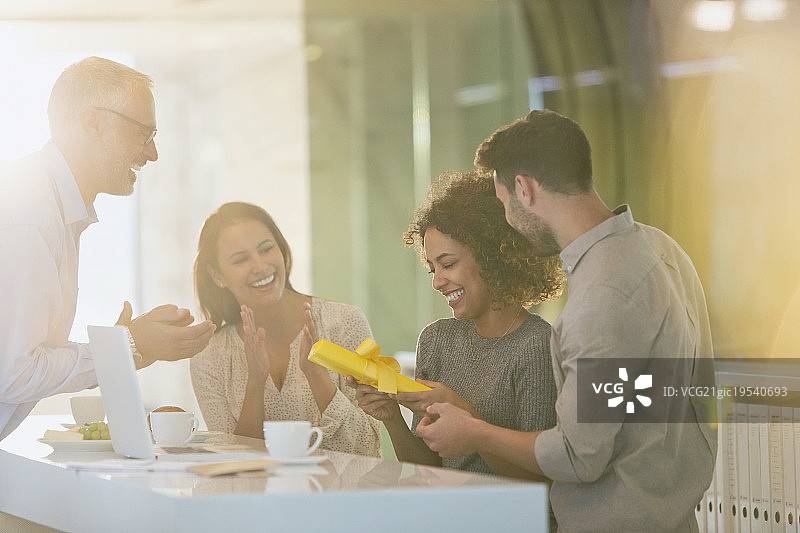 办公室里同事给女商人送礼物图片素材