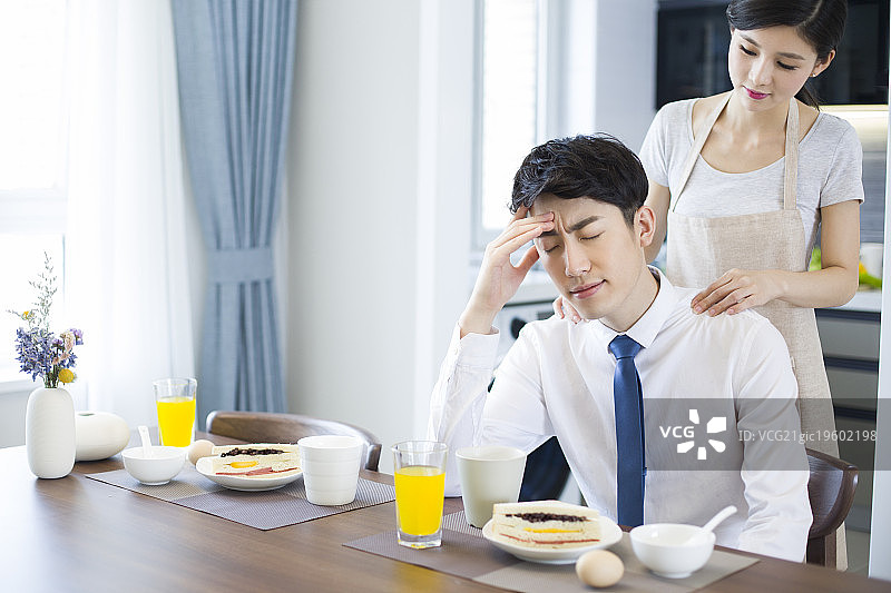 年轻妻子给疲倦的丈夫按摩肩膀图片素材