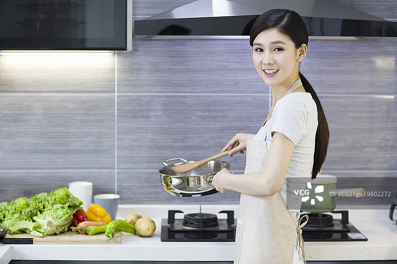 年轻女子在厨房做饭图片素材