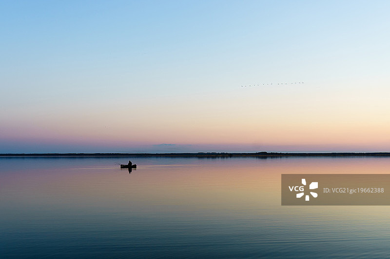 日出时渔民在传统船上图片素材