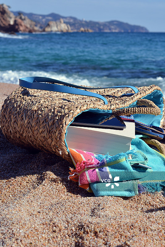 装有书和电话的沙滩包图片素材