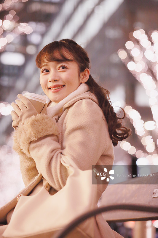 在户外喝咖啡的迷人年轻日本女性图片素材