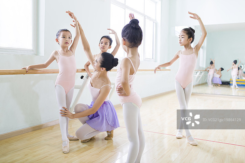 年轻舞蹈老师教小女孩们跳芭蕾图片素材