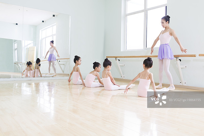 年轻舞蹈老师教小女孩们跳芭蕾图片素材