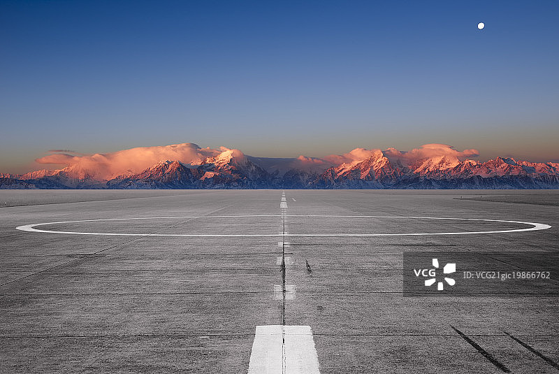 日出金色雪山背景的机场停机坪图片素材